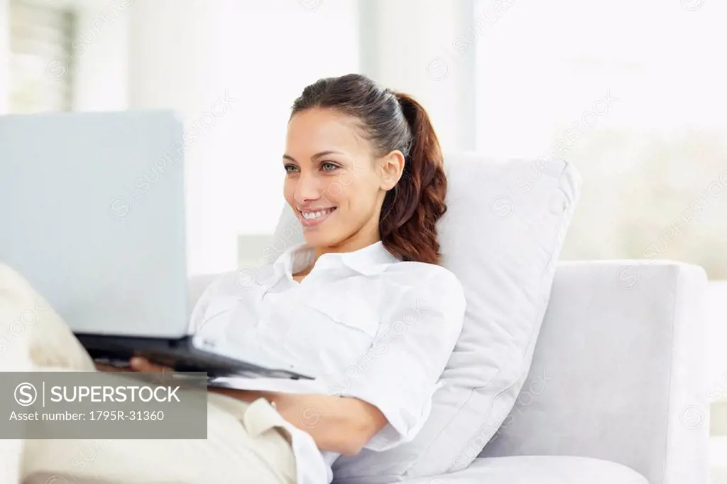 Woman relaxing on couch with laptop
