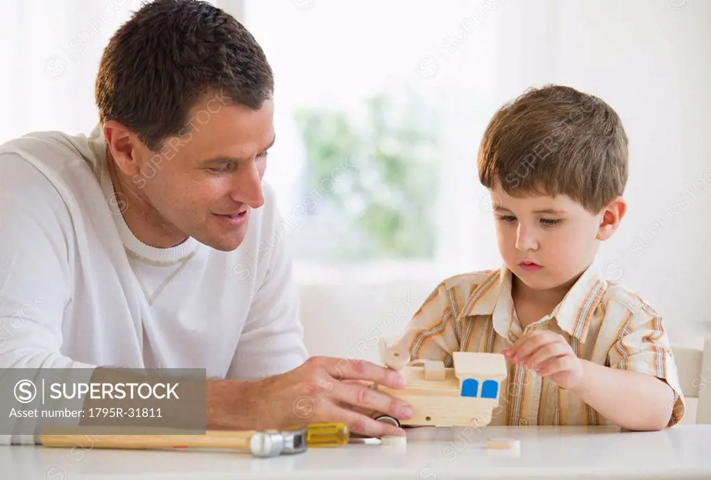 Father and son building a wooden train