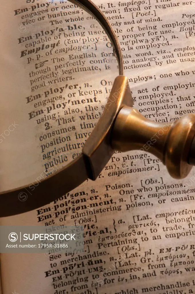 Magnifying glass over dictionary