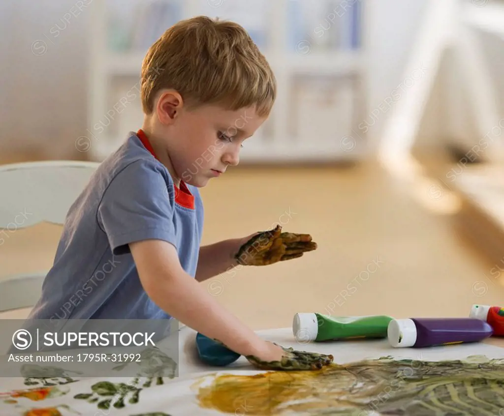 Young boy finger painting