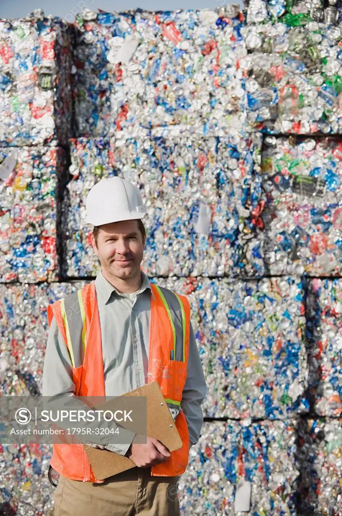 Worker standing in front of crushed aluminum cans