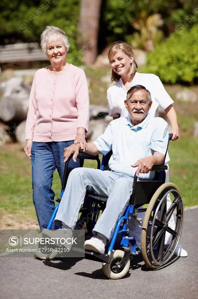 Two women walking with man in a wheelchair