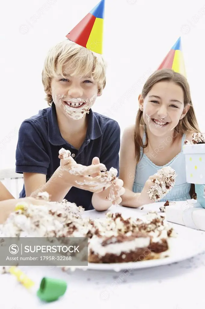 Children eating birthday cake with their hands