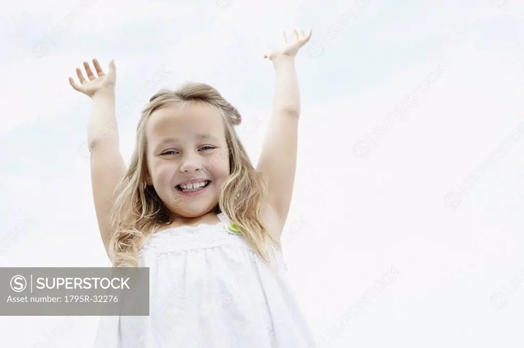 Young girl with her arms raised