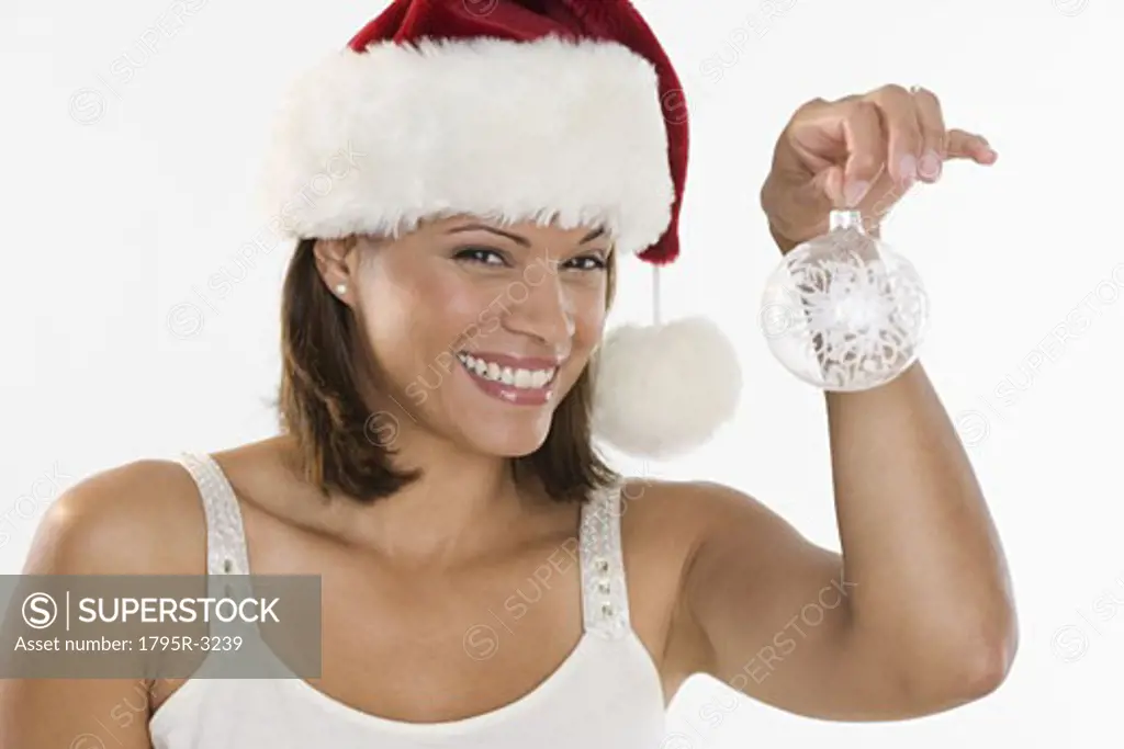 Woman wearing Santa hat holding ornament