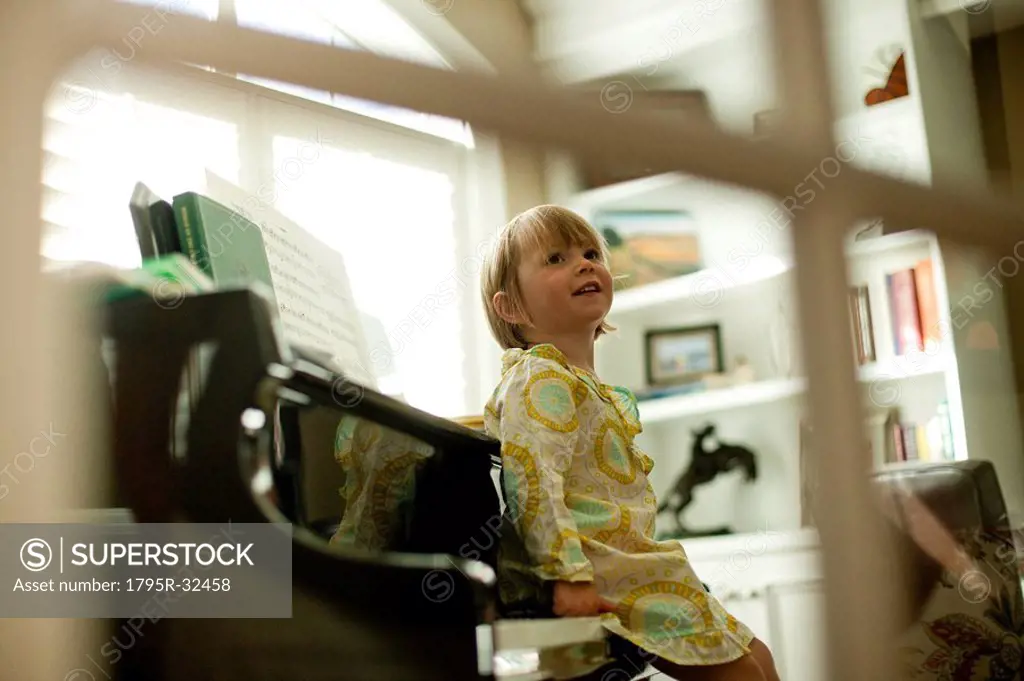Young girl sitting on piano