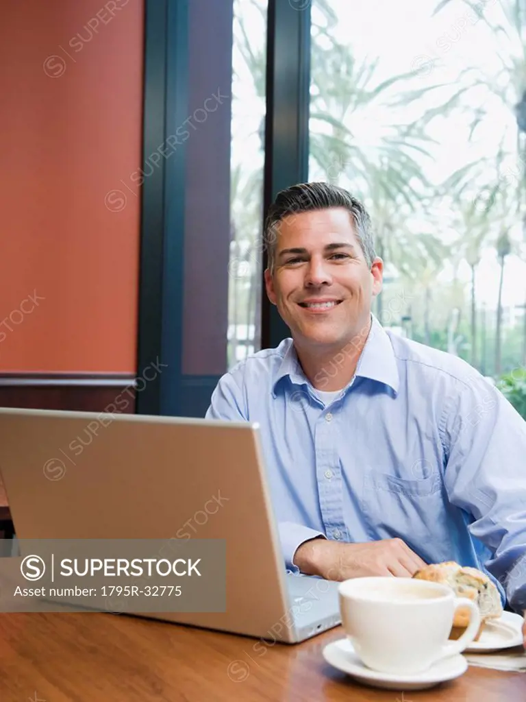 Man working on laptop in restaurant