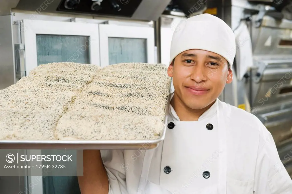 Chef holding tray of bread