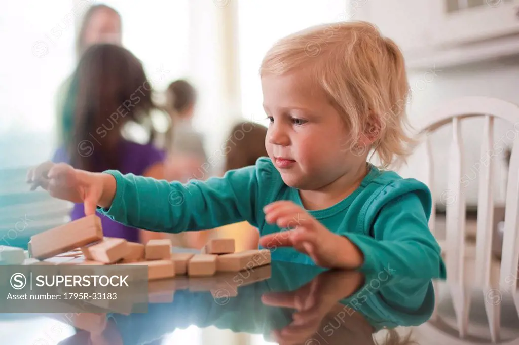 Young girl playing with wooden blocks