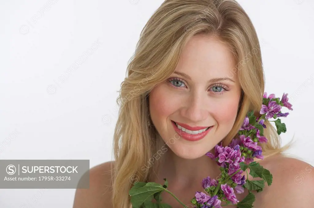 Blond woman holding purple flowers