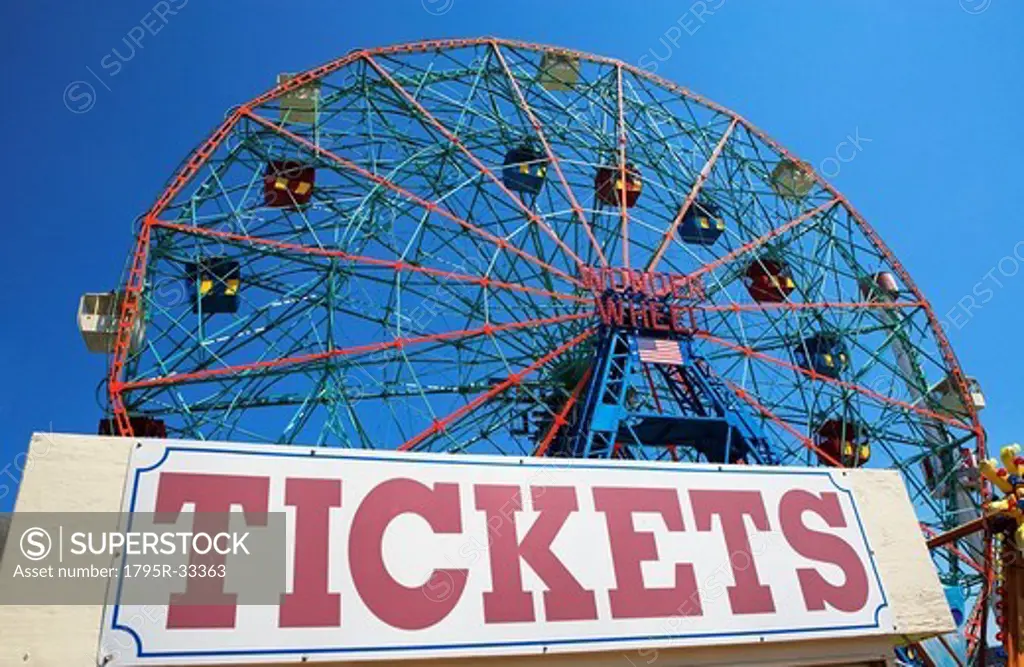 Ferris wheel and tickets sign at fairgrounds
