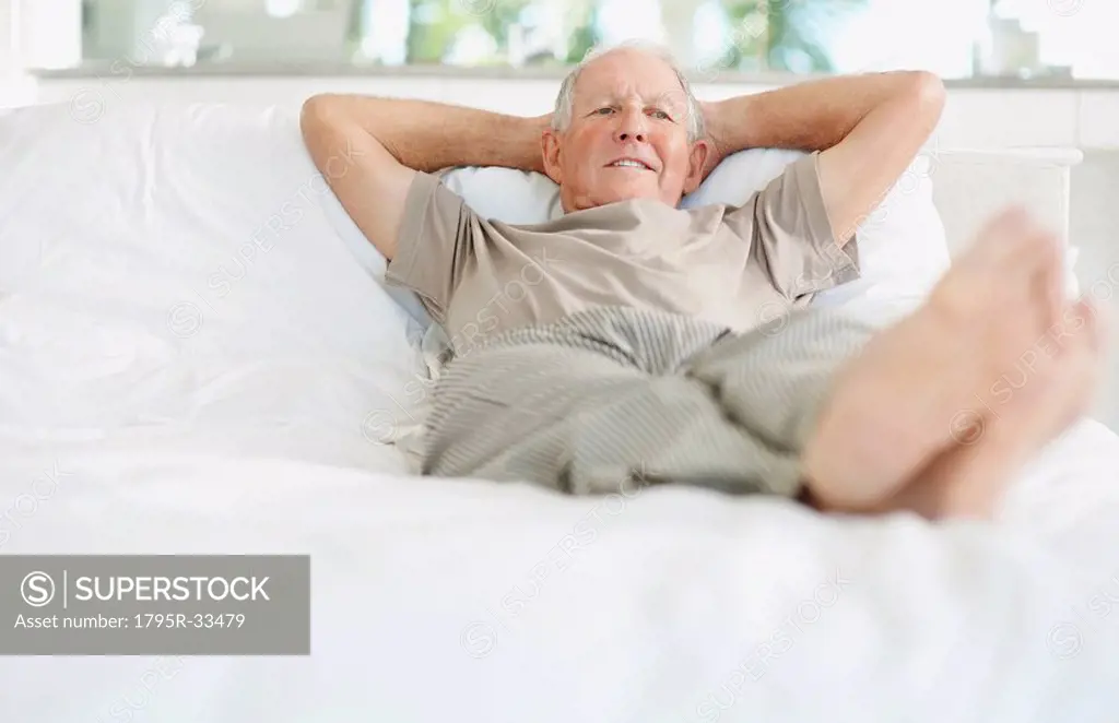 Relaxed senior man lying on bed