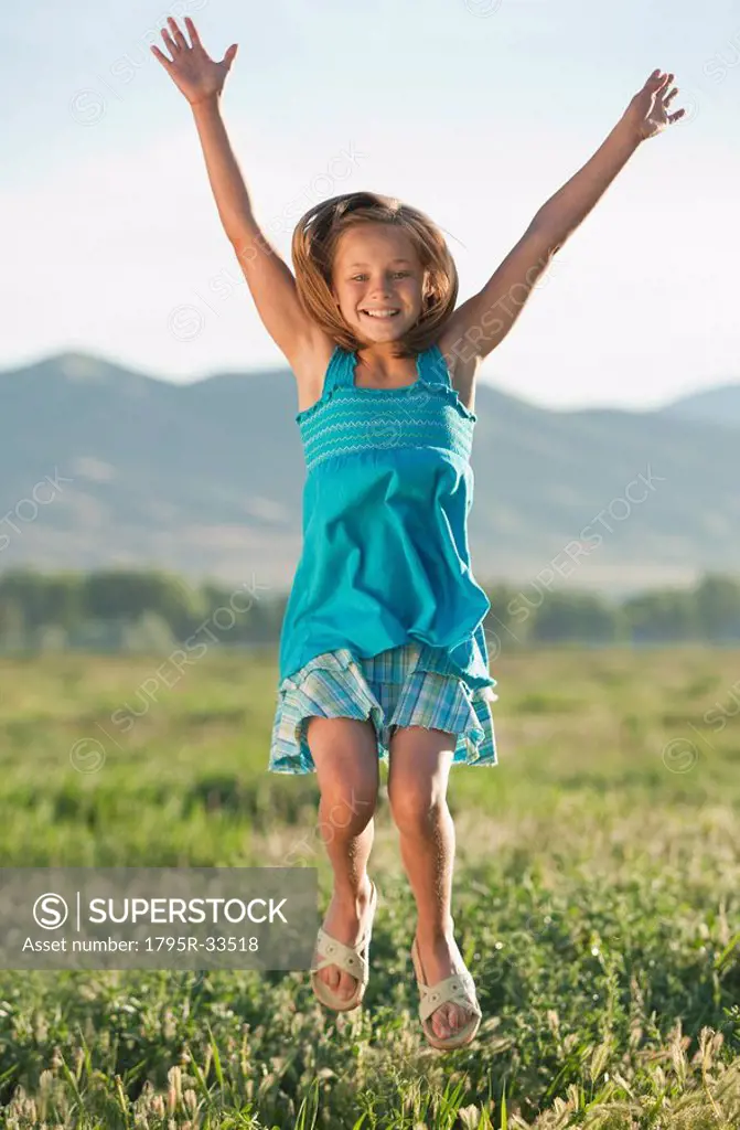 Young girl jumping in field