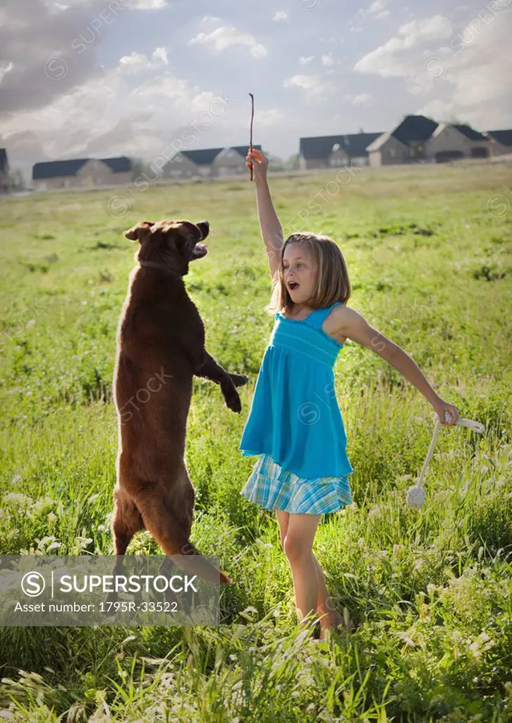 Young girl playing with her dog