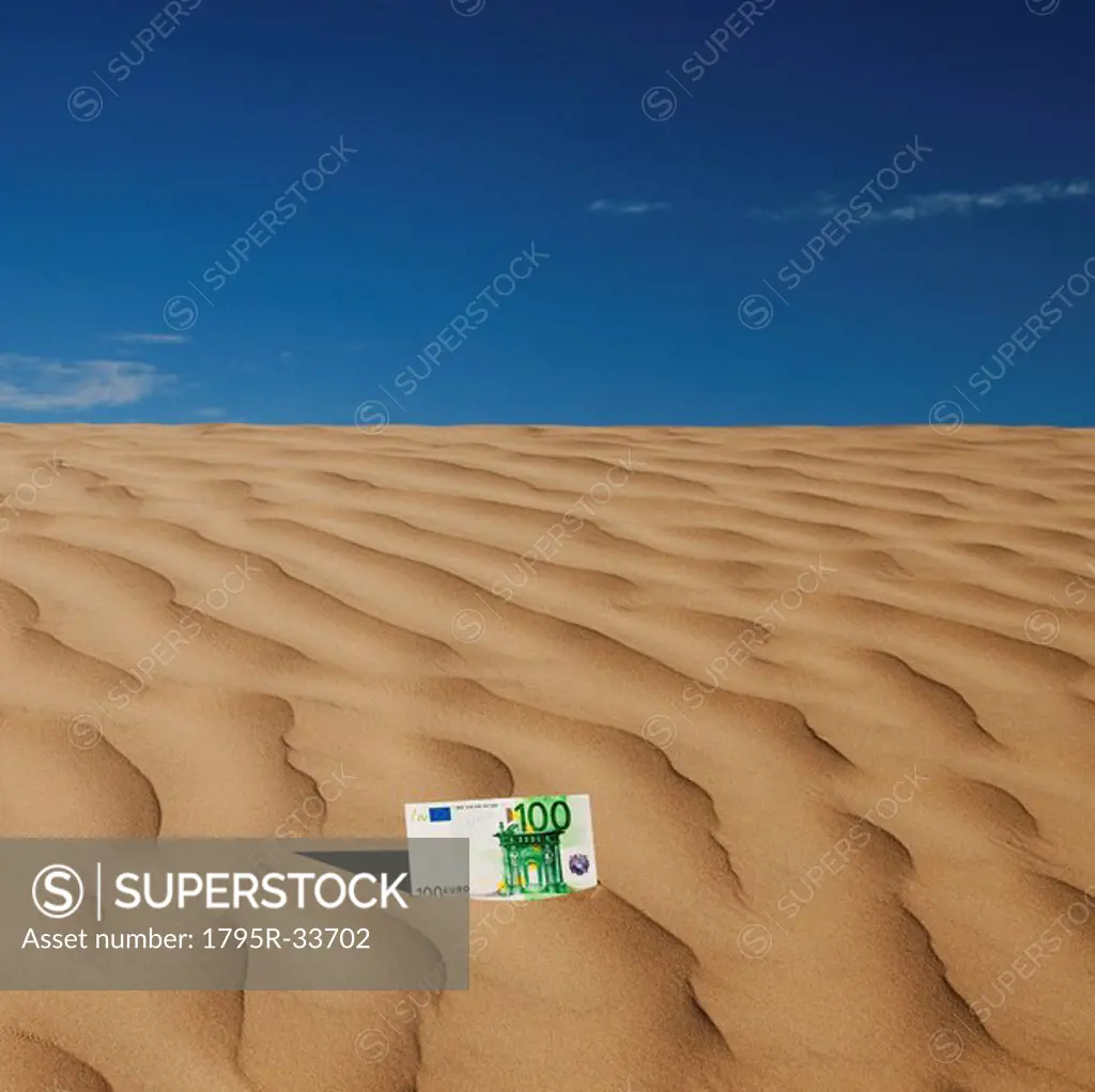 100 euro bill on sand in desert