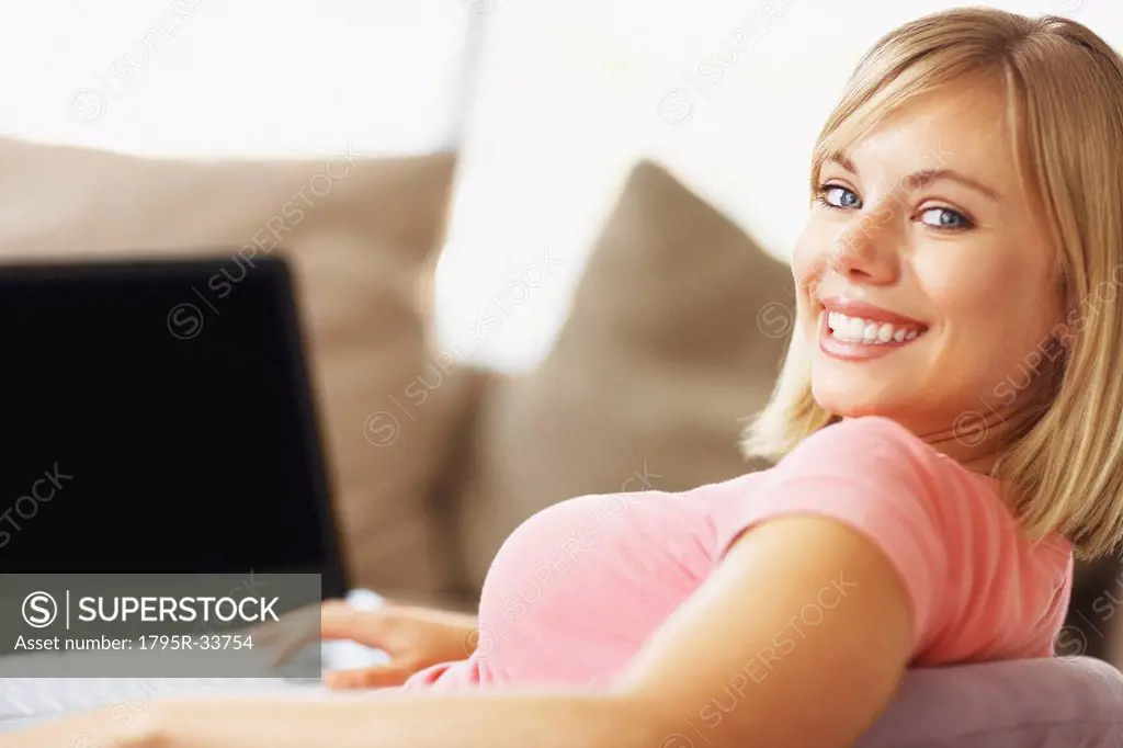 Portrait of young blonde woman using laptop