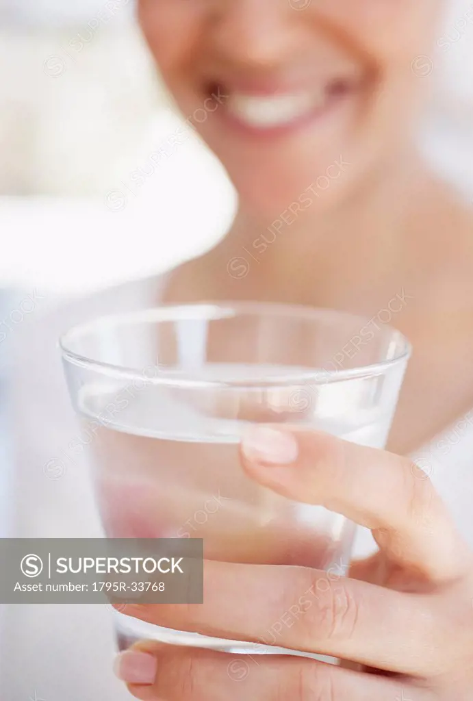 Close_up of woman holding glass of water