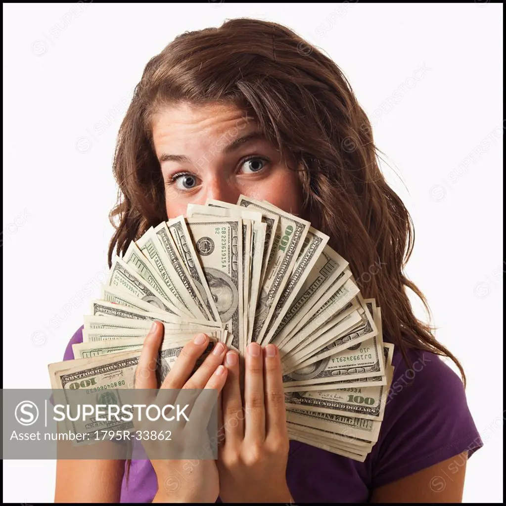 Young woman holding fanned out banknotes