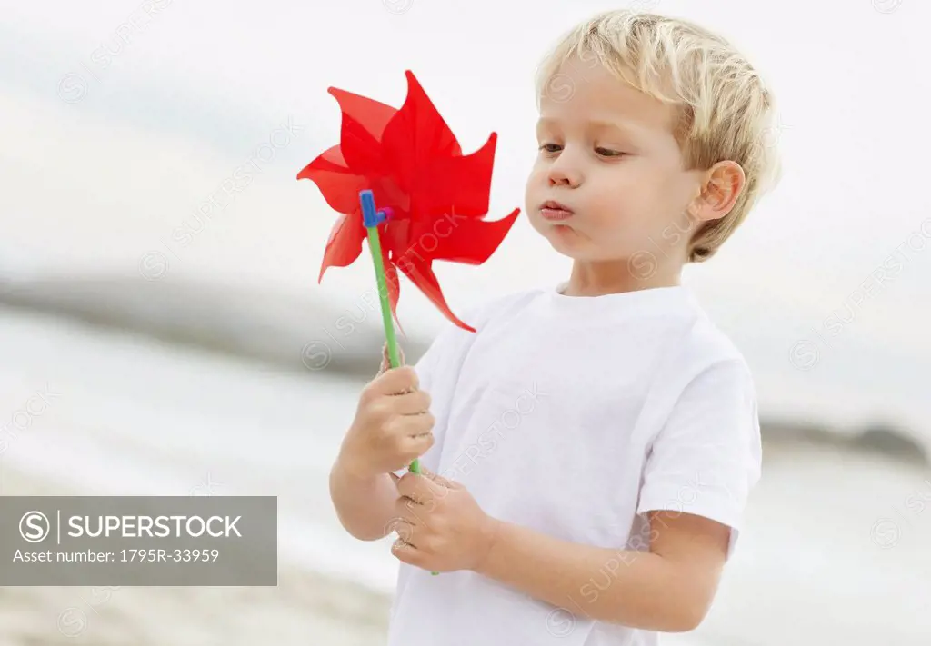 Portrait of boy 4_5 playing with pinwheel on beach