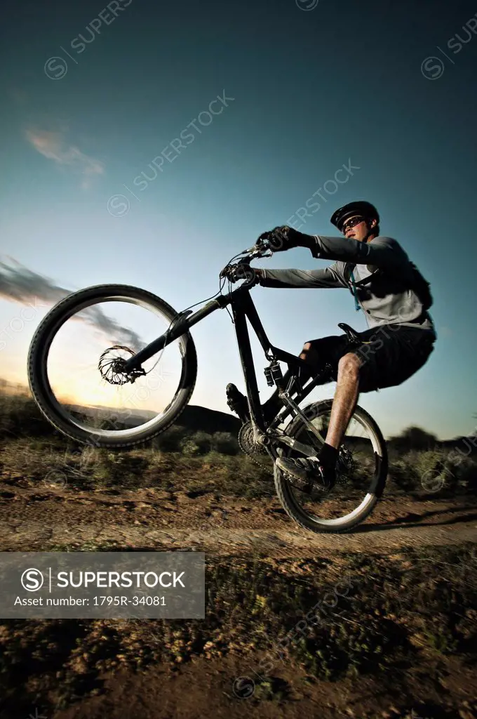 Man mountain biking on dirt track