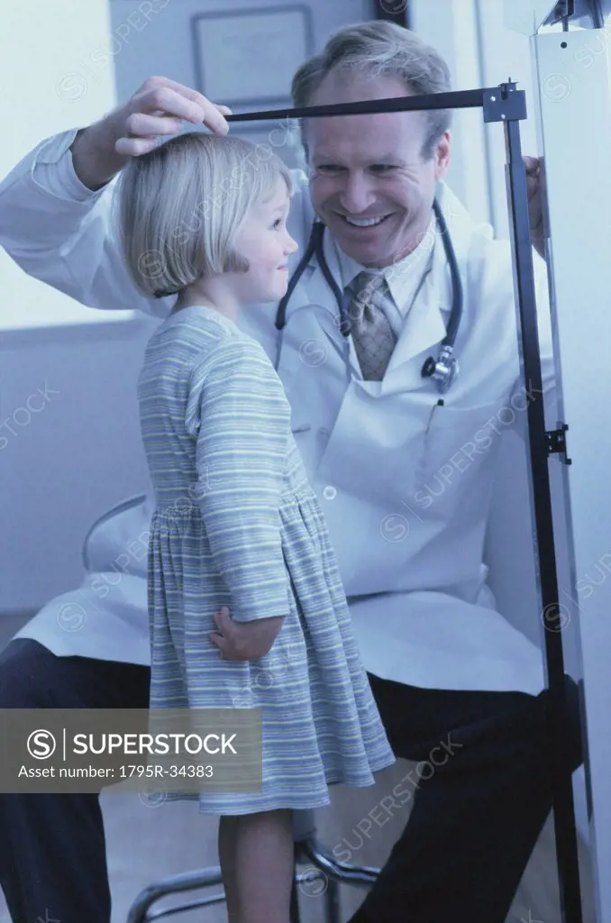 Doctor measuring young girl´s growth