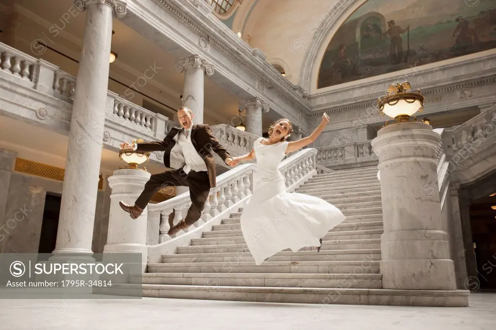 Bride and groom leaping from steps