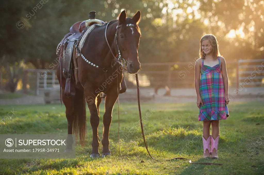 Girl 8_9 standing with horse in paddock