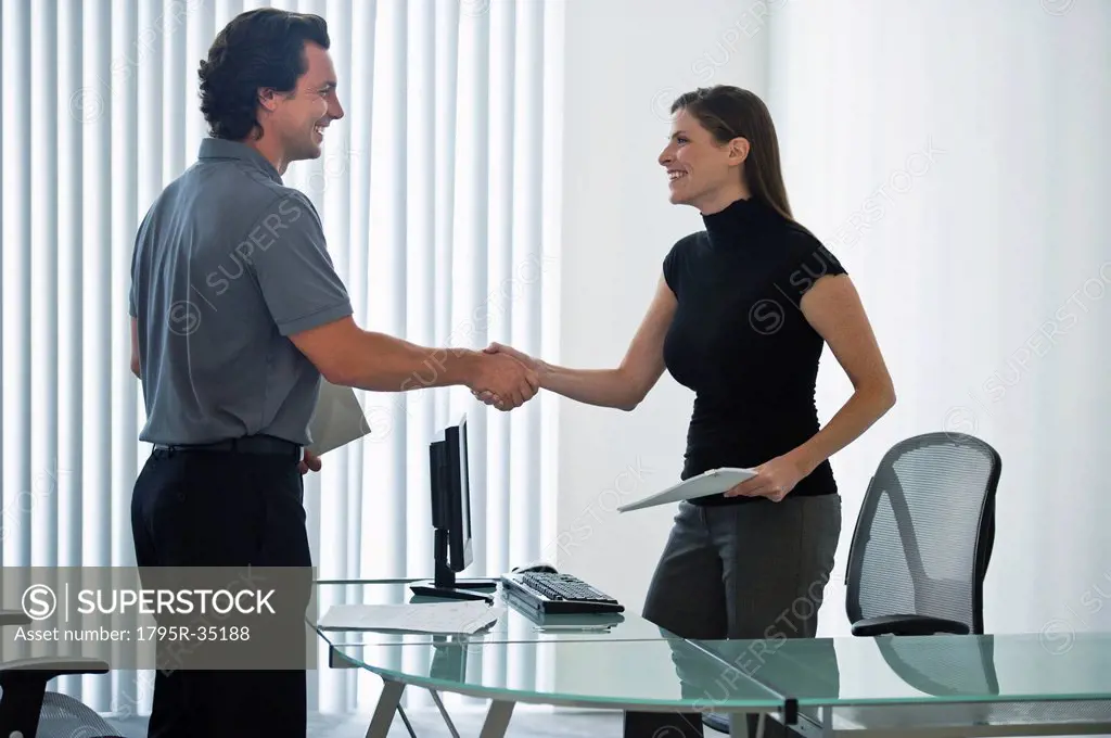 Man and woman in office shaking hands