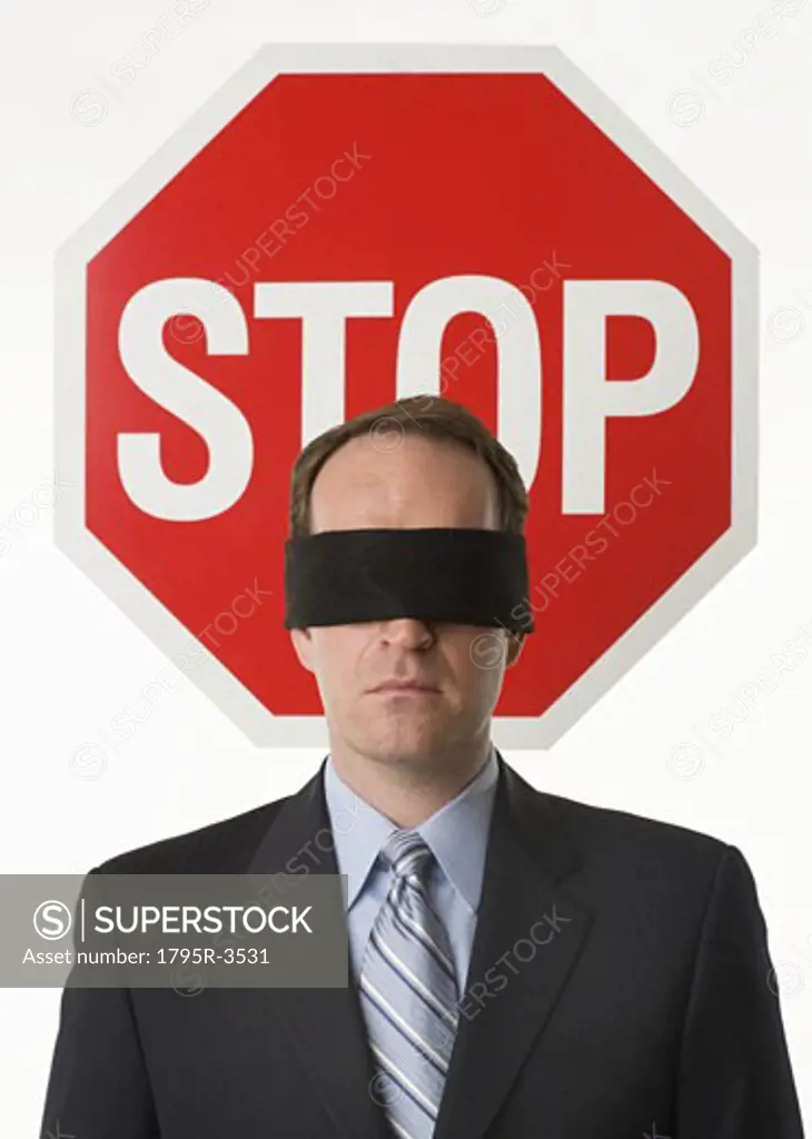 Man wearing blindfold at stop sign