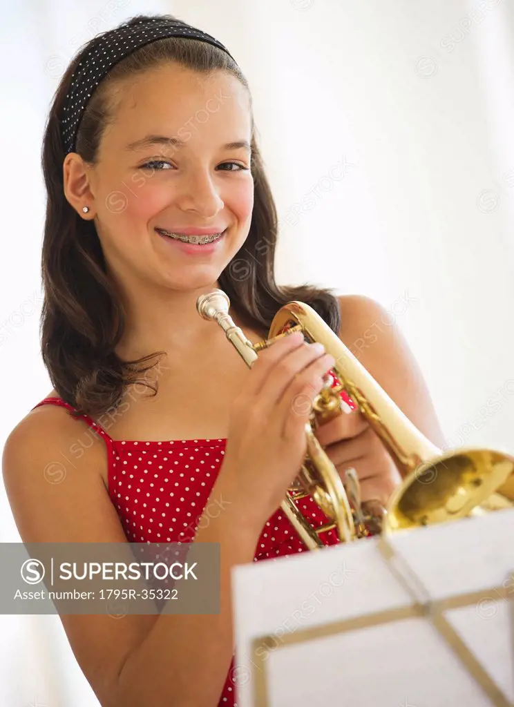 Portrait of girl 12_13 with trumpet looking at camera