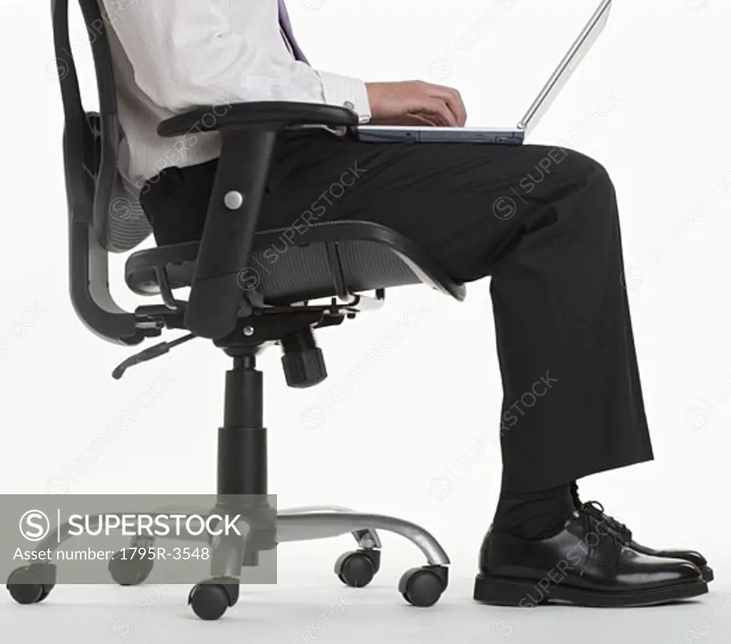 Seated businessman using laptop computer