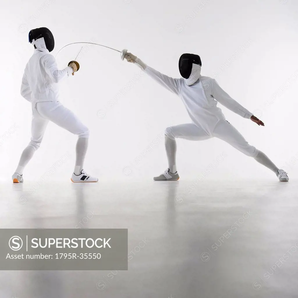 Studio shot of fencers in attacking lunge