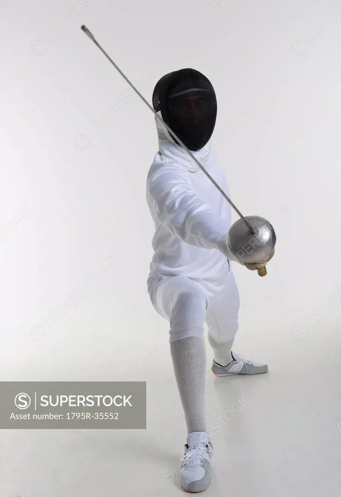 Studio portrait of fencer holding fencing foil