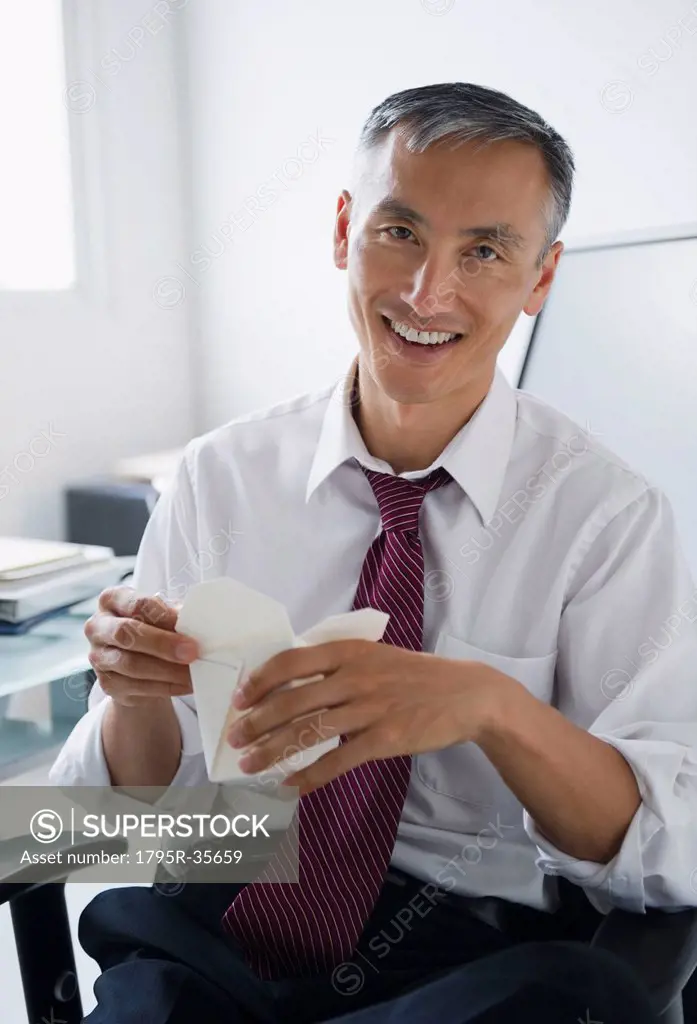 Portrait of smiling businessman holding Chinese take away