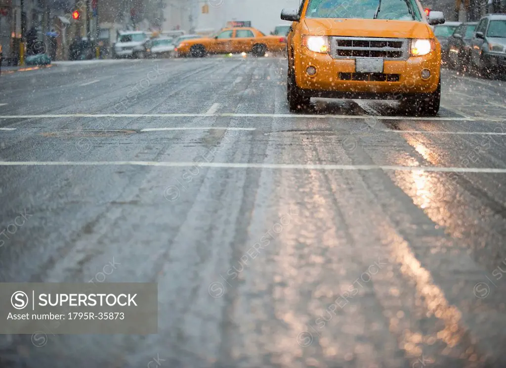 USA, New York, New York City, Yellow cab on street in snow