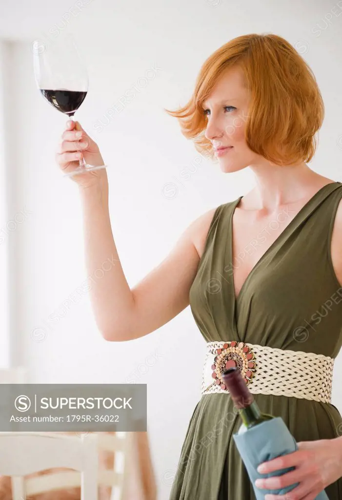 Young woman looking at glass of wine
