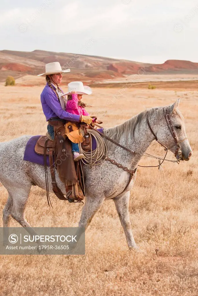 Mother and daughter riding horse