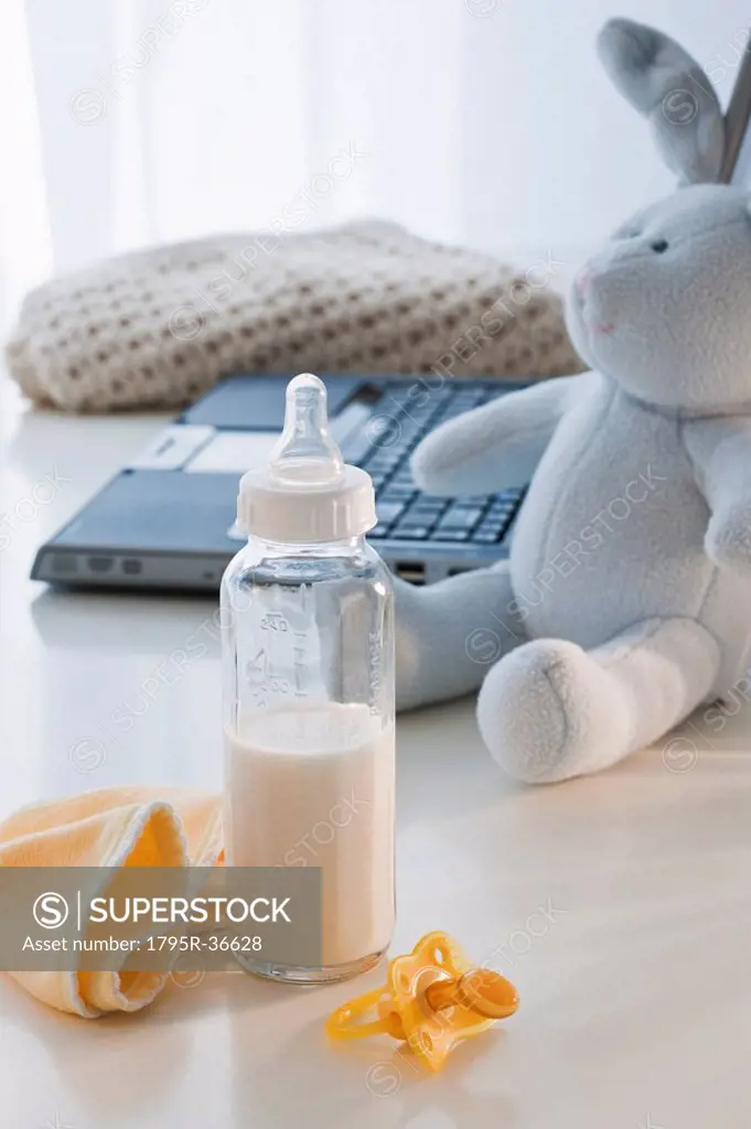 Baby bottle beside laptop