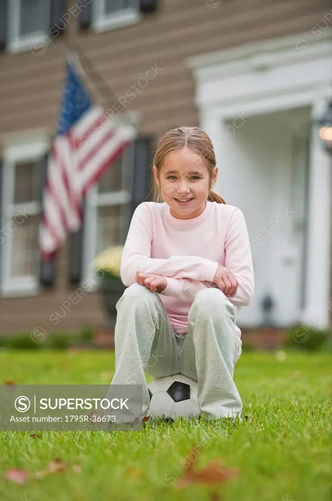Girl sitting on soccer ball
