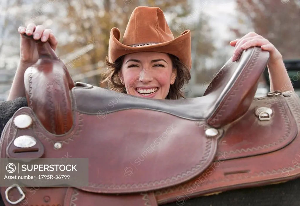 Woman holding saddle
