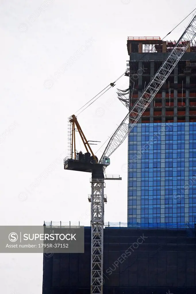 Crane beside high_rise building