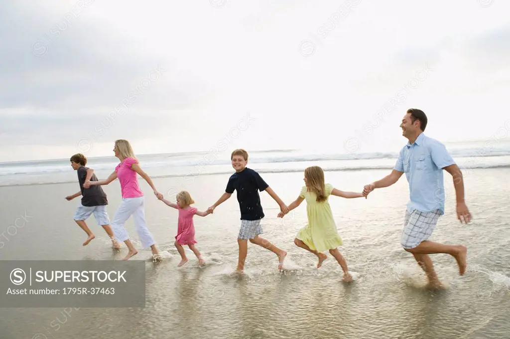 Family holding hands in ocean