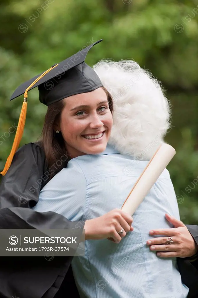 Graduate hugs elderly woman