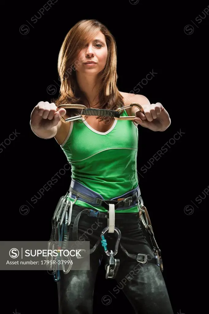 Studio shot of a female climber holding carabiners