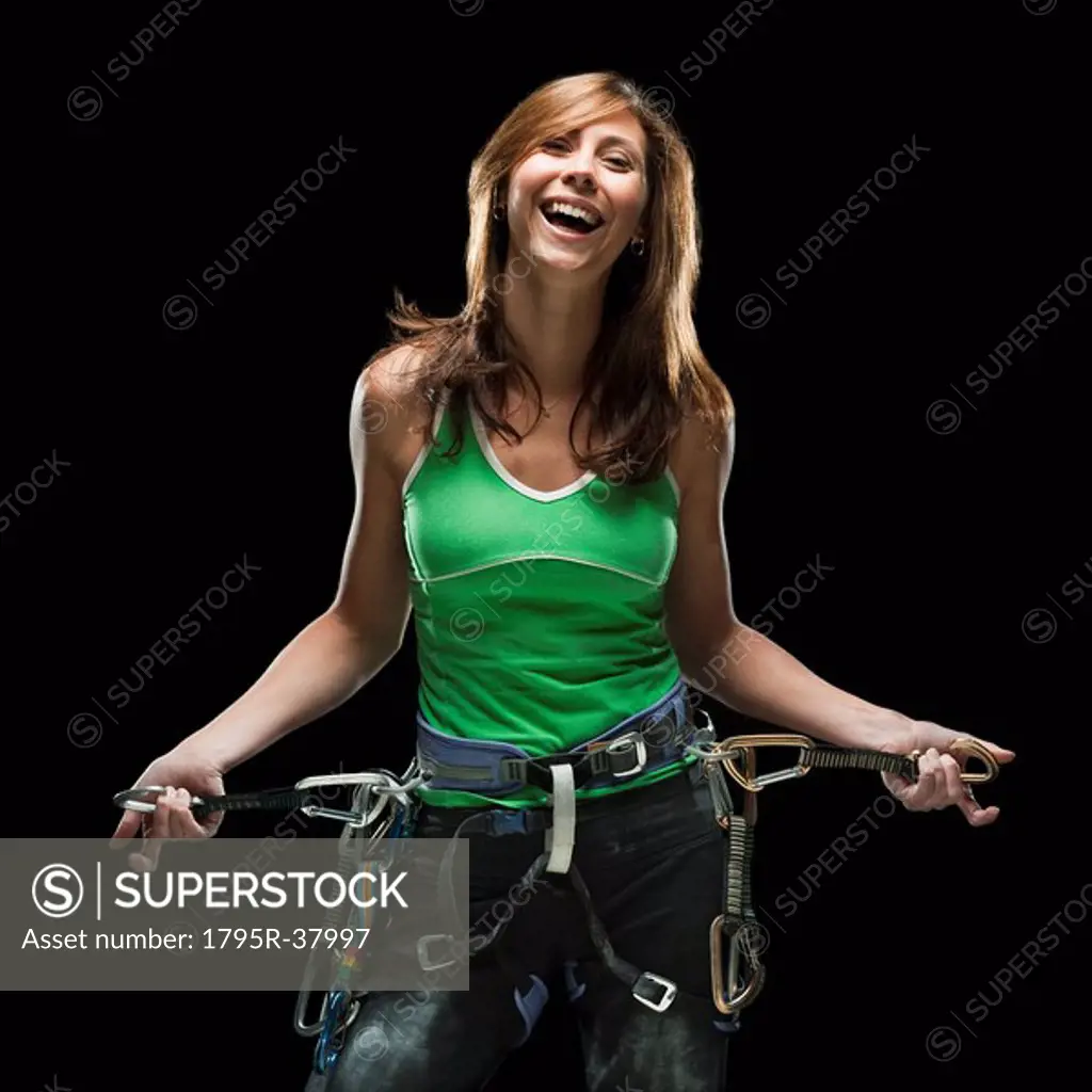 Smiling female climber holding carabiners