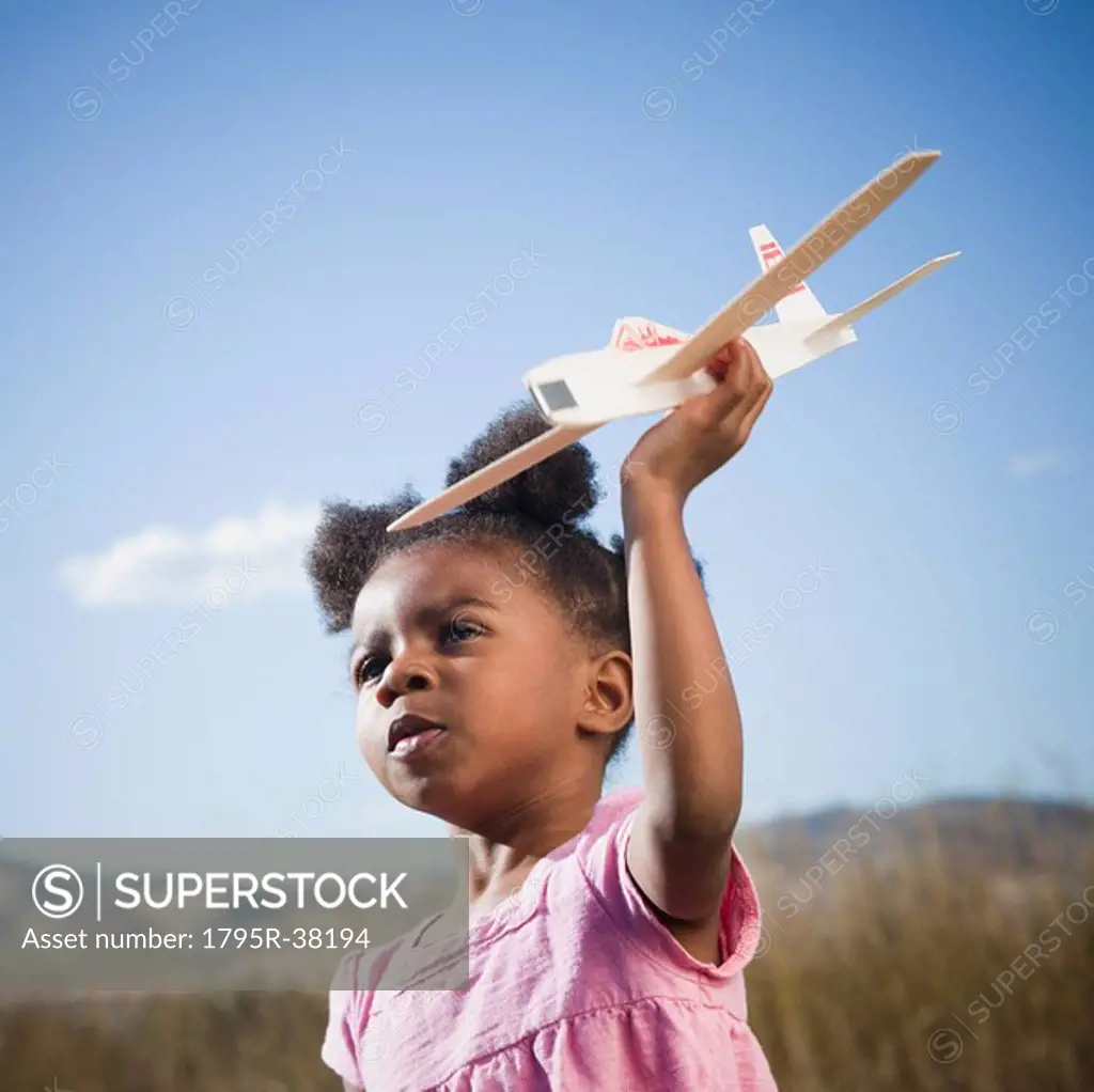 Young girl playing with toy airplane