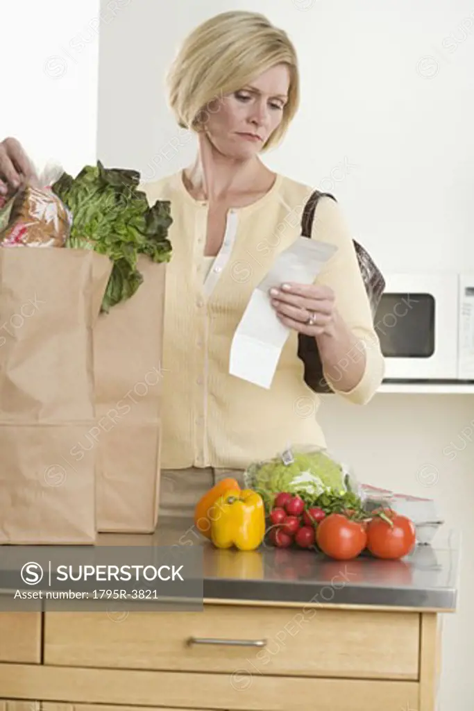 Woman checking grocery receipt