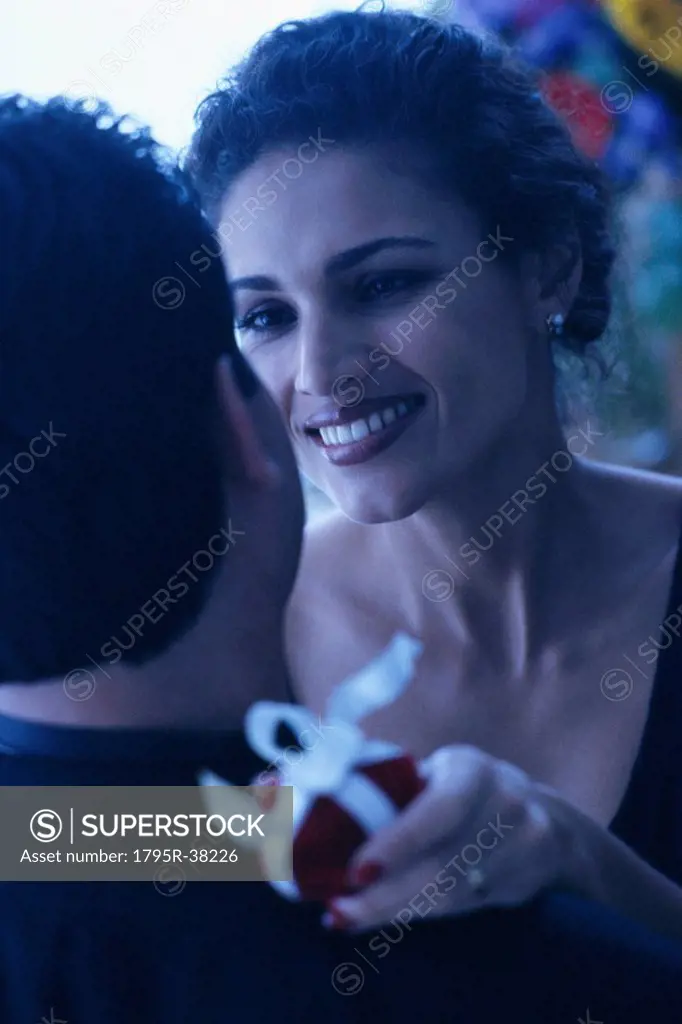 Couple embrace with gift in hand