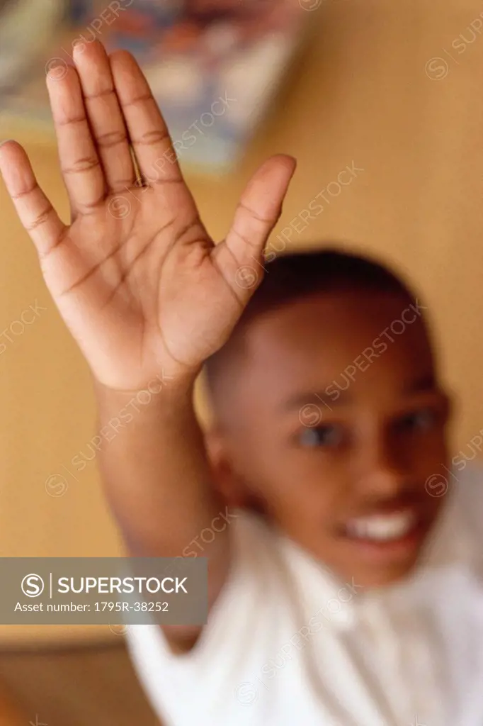 Child raising hand in classroom