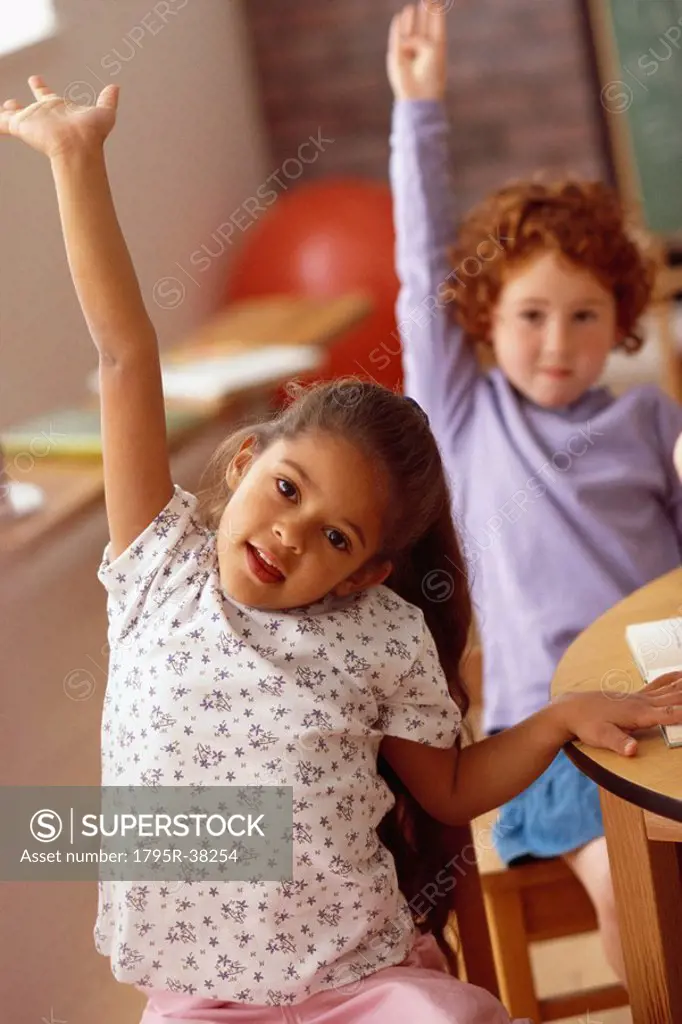 Girls raising hands in classroom